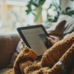 A person reading manga on a tablet in a cozy setting.