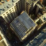 Futuristic solar panel installation in urban setting captured by drone.